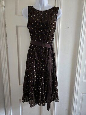 Brown sleeveless polka dot dress with a sheer overlay,